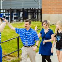 Three guests giving Louie the Laker a high-five at the Jamie Hosford Football Center dedication.